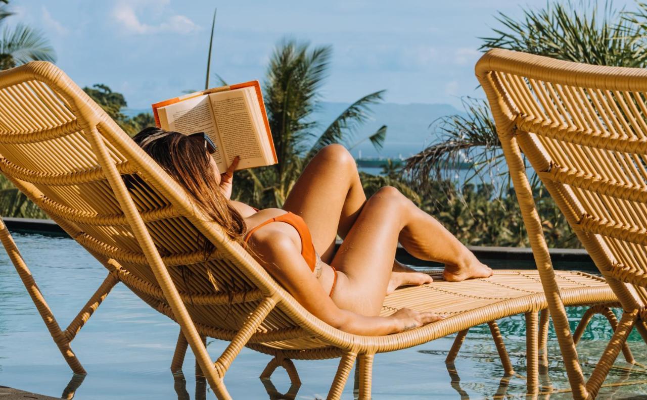 Neano Escape Hotel Manggis  Luaran gambar A woman reading a book on a beach